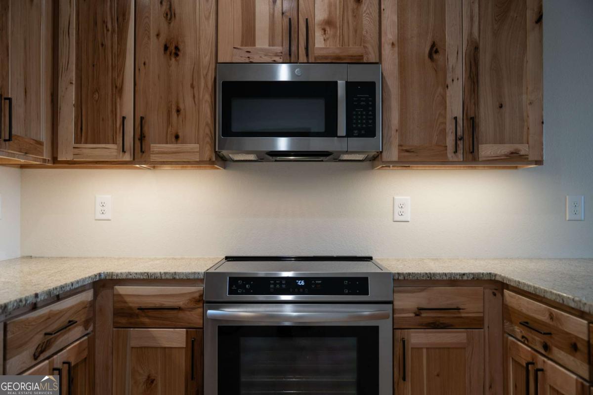 802 Mull Valley Road Morganton, GA 30560 - Photo 51 of 75 a kitchen with granite countertop a stove and a microwave