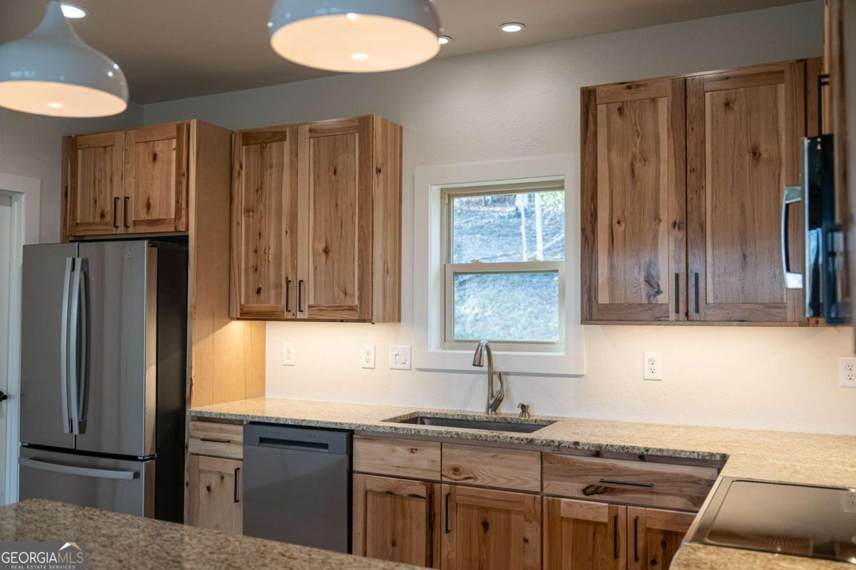 802 Mull Valley Road Morganton, GA 30560 - Photo 63 of 75 a kitchen with granite countertop a refrigerator stove and sink