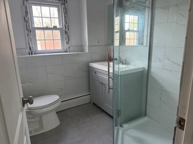 a bathroom with a sink toilet and window