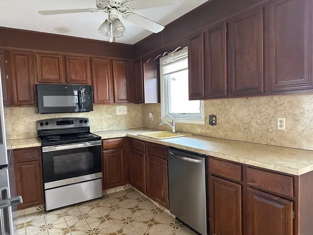 a kitchen with a sink stove and microwave
