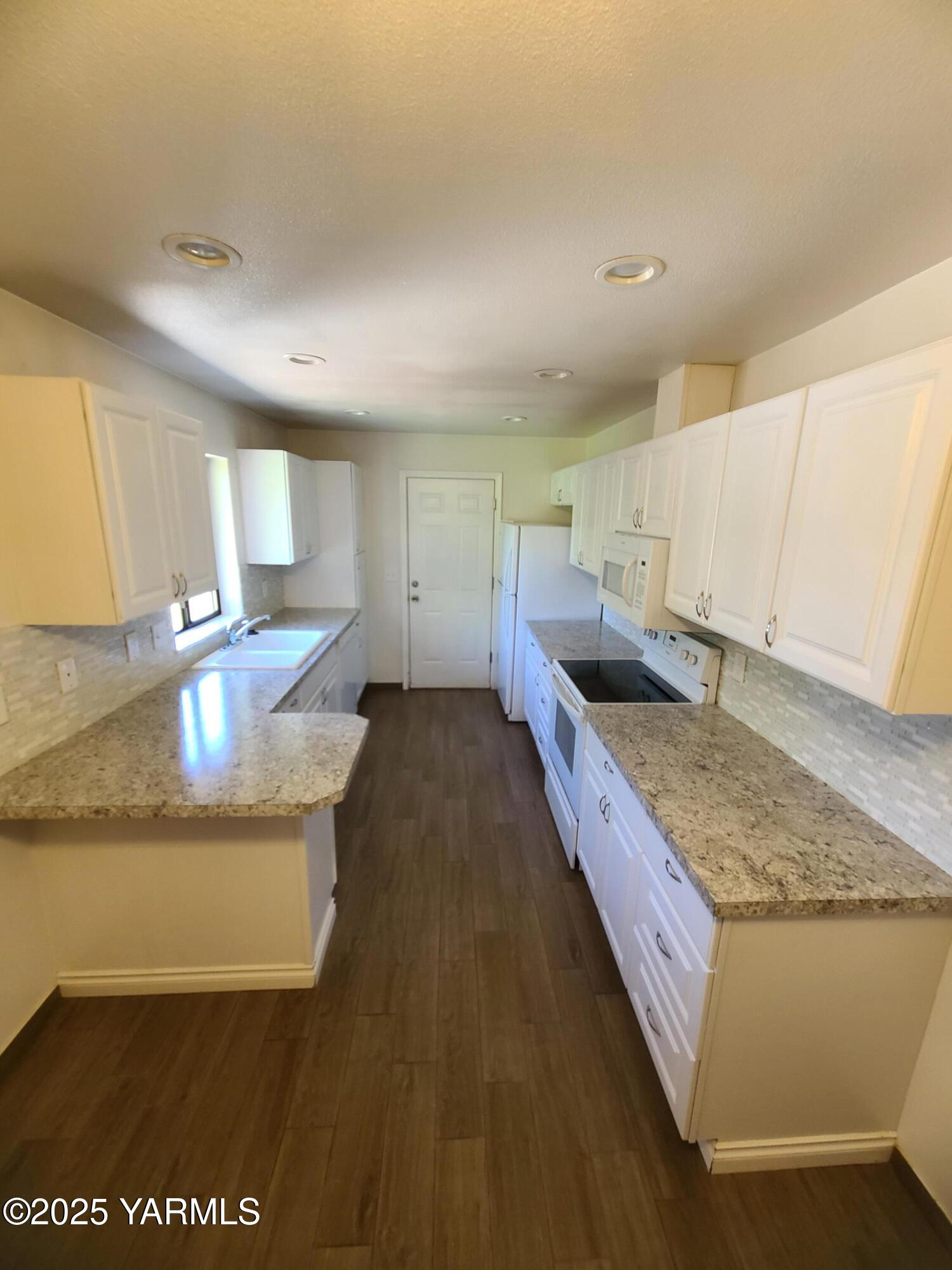 9509 Meadowbrook Road Yakima, WA 98903 - Photo 13 of 14 a kitchen with stainless steel appliances granite countertop a sink and a stove
