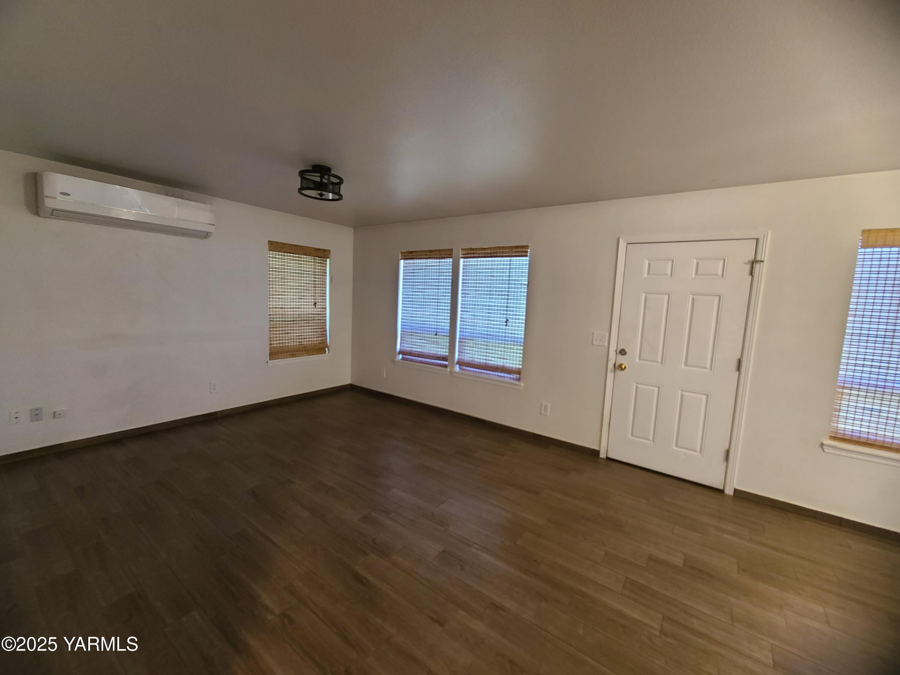 9509 Meadowbrook Road Yakima, WA 98903 - Photo 8 of 14 an empty room with wooden floor and windows