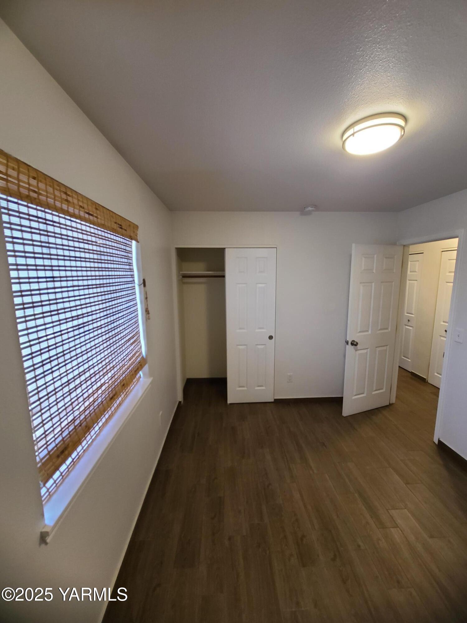 9509 Meadowbrook Road Yakima, WA 98903 - Photo 10 of 14 an empty room with wooden floor and windows