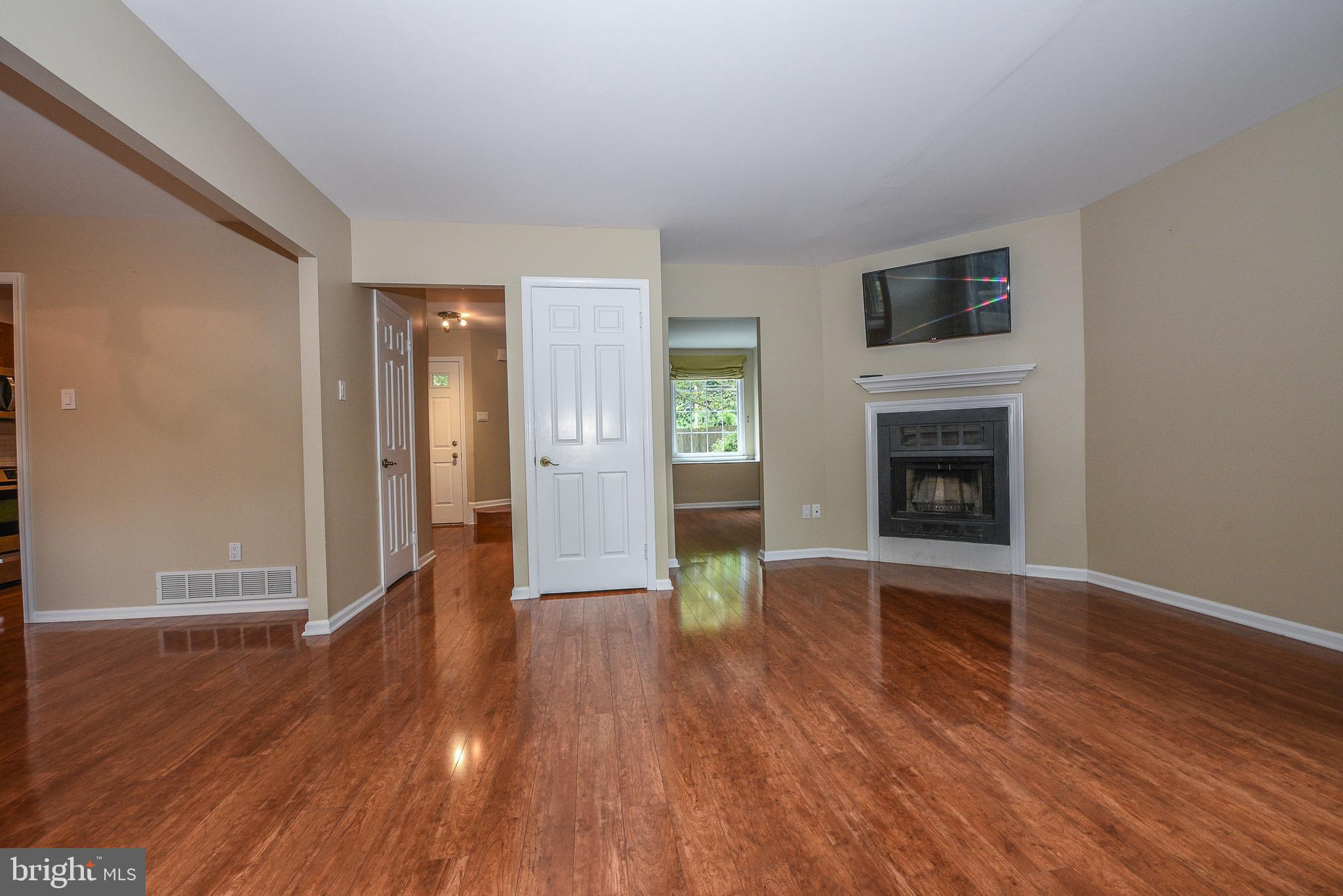 429 Eagle Road Wayne, PA 19087 - Photo 17 of 41 a view of an empty room with wooden floor fireplace and a window