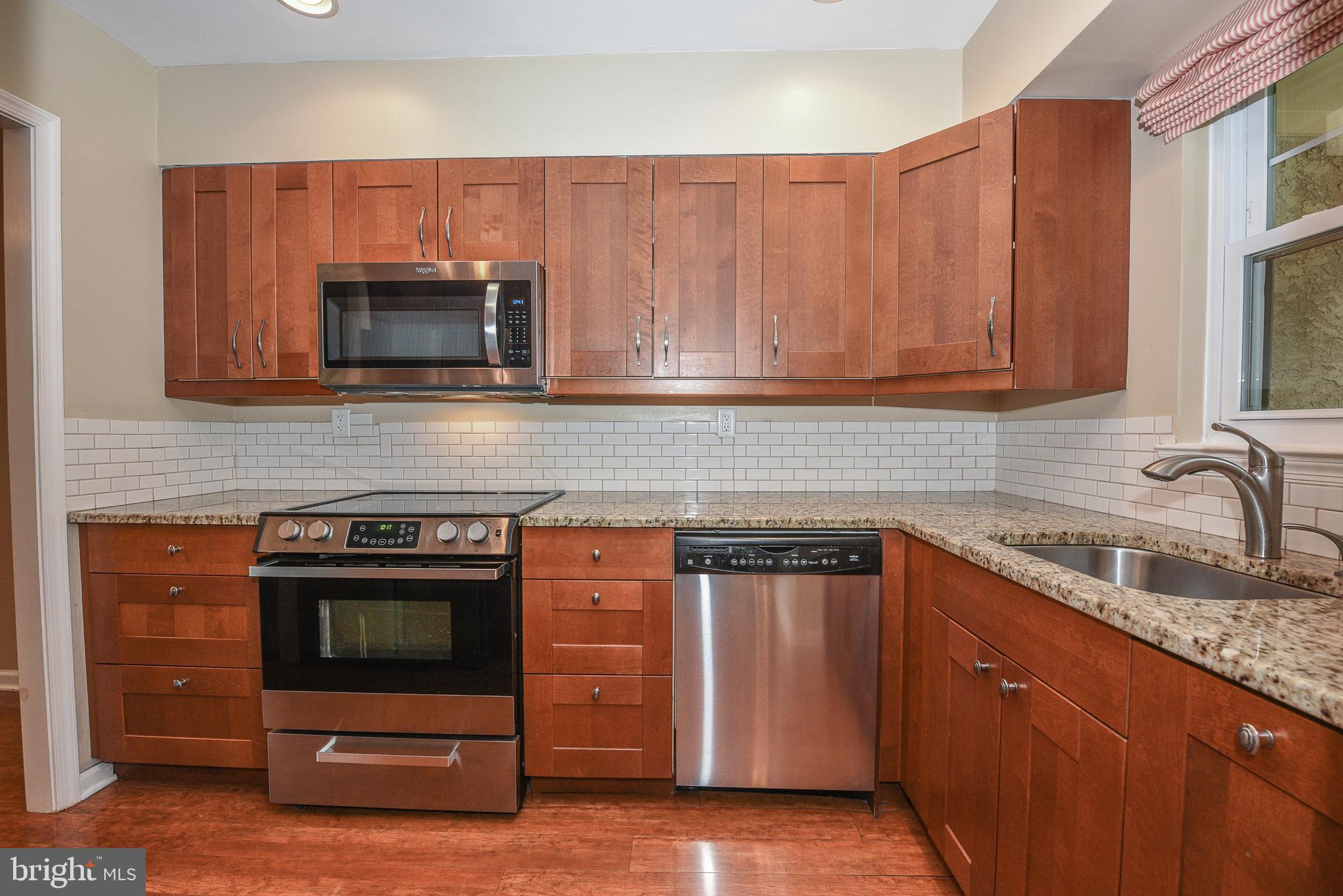429 Eagle Road Wayne, PA 19087 - Photo 6 of 41 a kitchen with granite countertop a stove microwave and sink