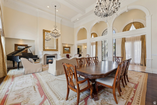 1714 Ridge Point Drive Bountiful, UT 84010 - Photo 26 of 132 Grand great room featuring high ceilings, multiple chandeliers, arched doorways, a fireplace with a decorative mantel, and wood-finish flooring