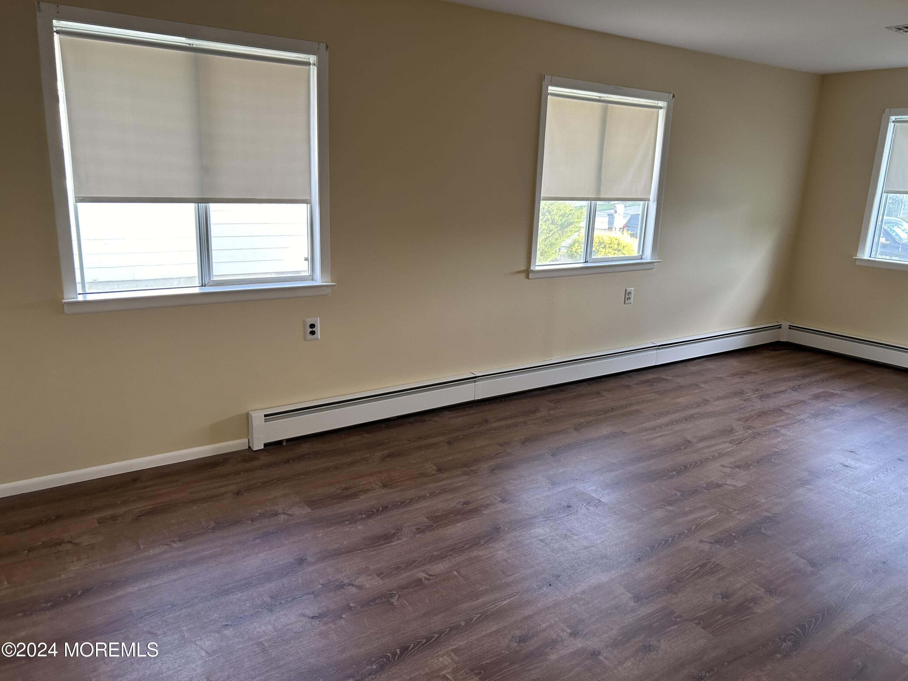 38 Eldorado Street Toms River, NJ 08757 - Photo 7 of 11 an empty room with wooden floor and windows