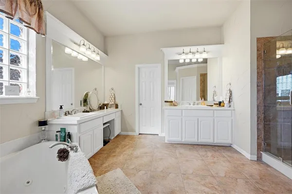 a large white bathroom with a sink mirror and a bathtub