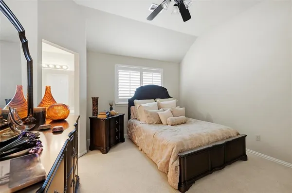 a bedroom with a bed and dresser with large window