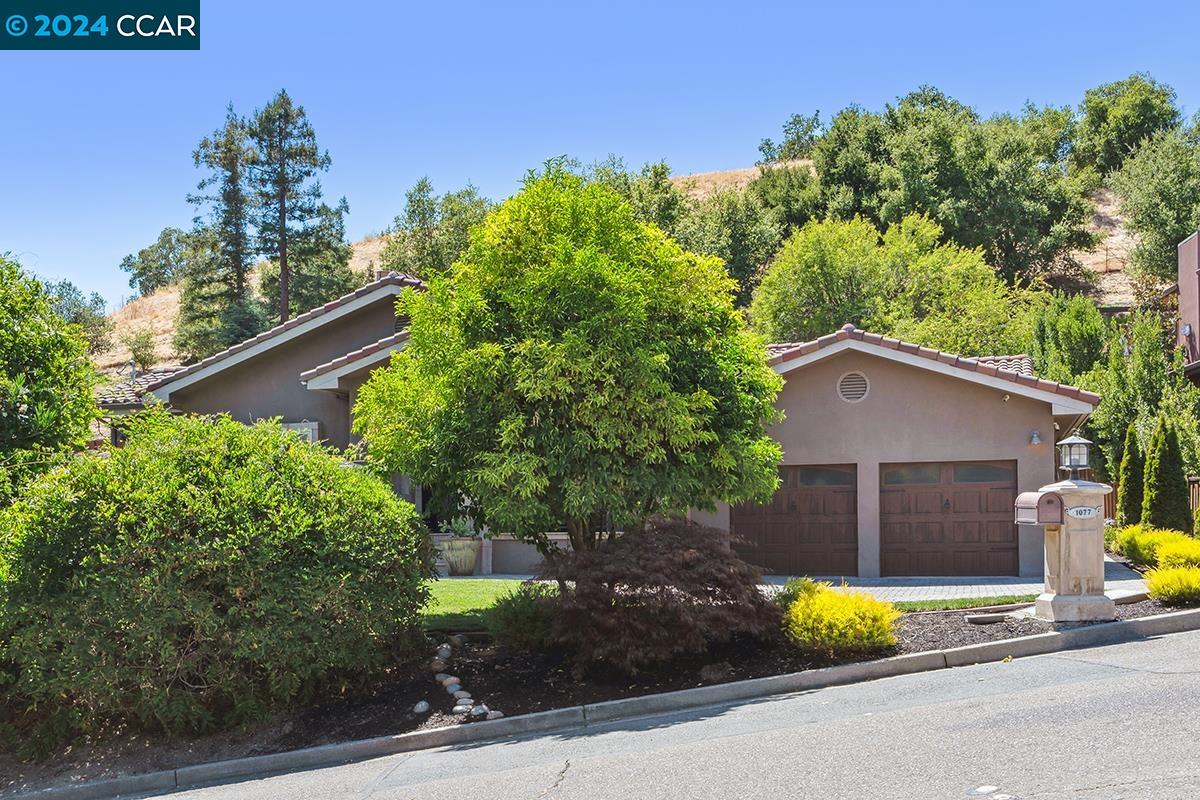 a view of a house with a yard and a garden