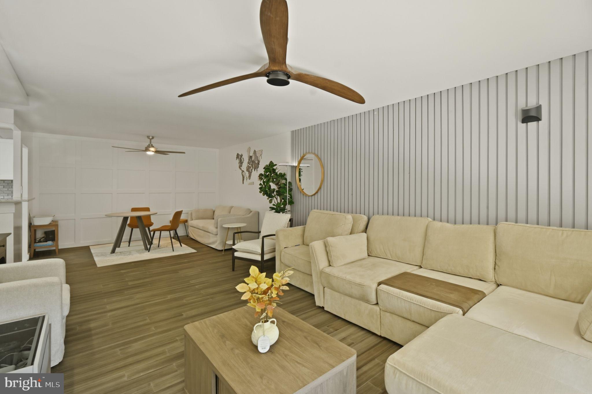 9701 Fields Road, Unit 200 Gaithersburg, MD 20878 - Photo 12 of 31 a living room with couches and kitchen view with wooden floor