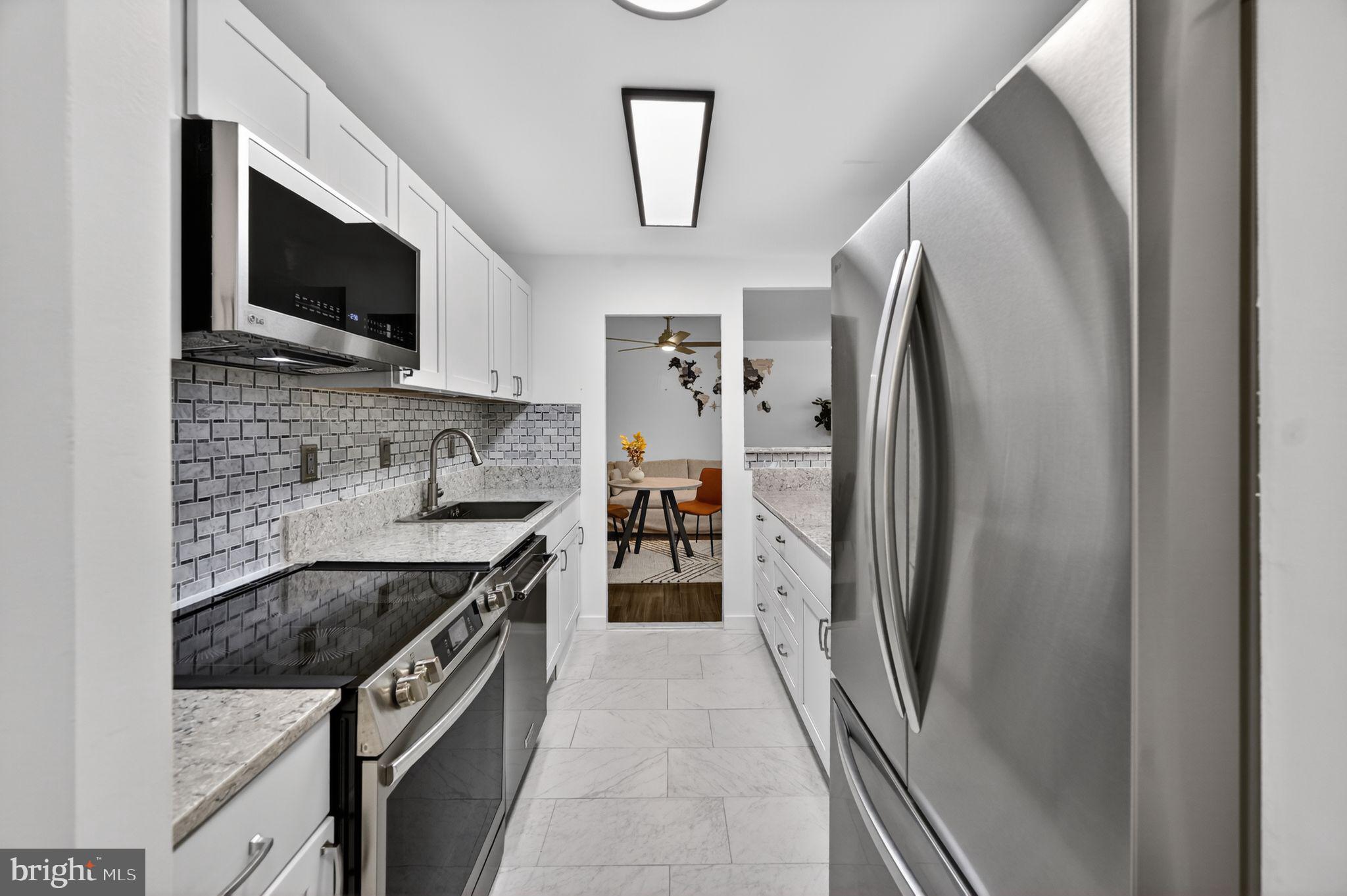 9701 Fields Road, Unit 200 Gaithersburg, MD 20878 - Photo 15 of 31 a kitchen with stainless steel appliances granite countertop a refrigerator a stove and a sink