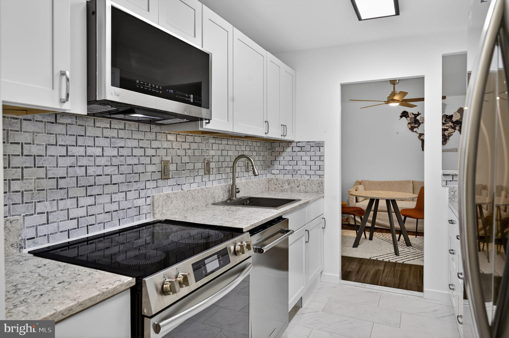 9701 Fields Road, Unit 200 Gaithersburg, MD 20878 - Photo 16 of 31 a kitchen with stainless steel appliances a stove a microwave and sink