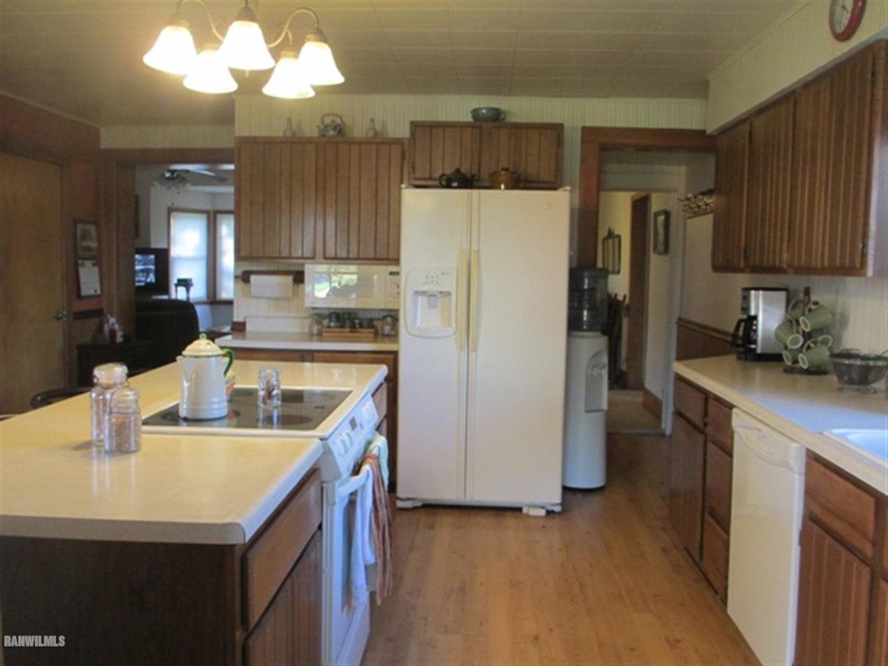22599 Fairhaven Road Chadwick, IL 61014 - Photo 3 of 23 a kitchen with a sink a refrigerator a stove and a kitchen island