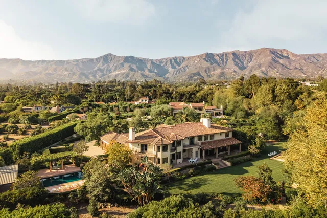an aerial view of a house with a mountain in the background