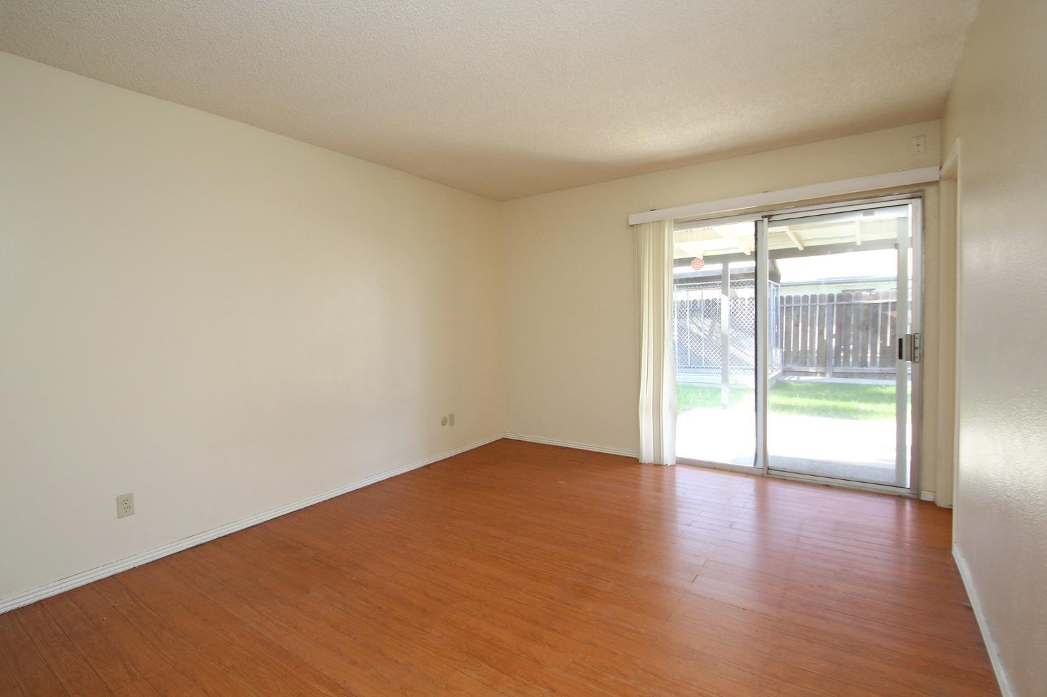 834 Fordham Avenue Clovis, CA 93611 - Photo 12 of 26 an empty room with wooden floor and windows