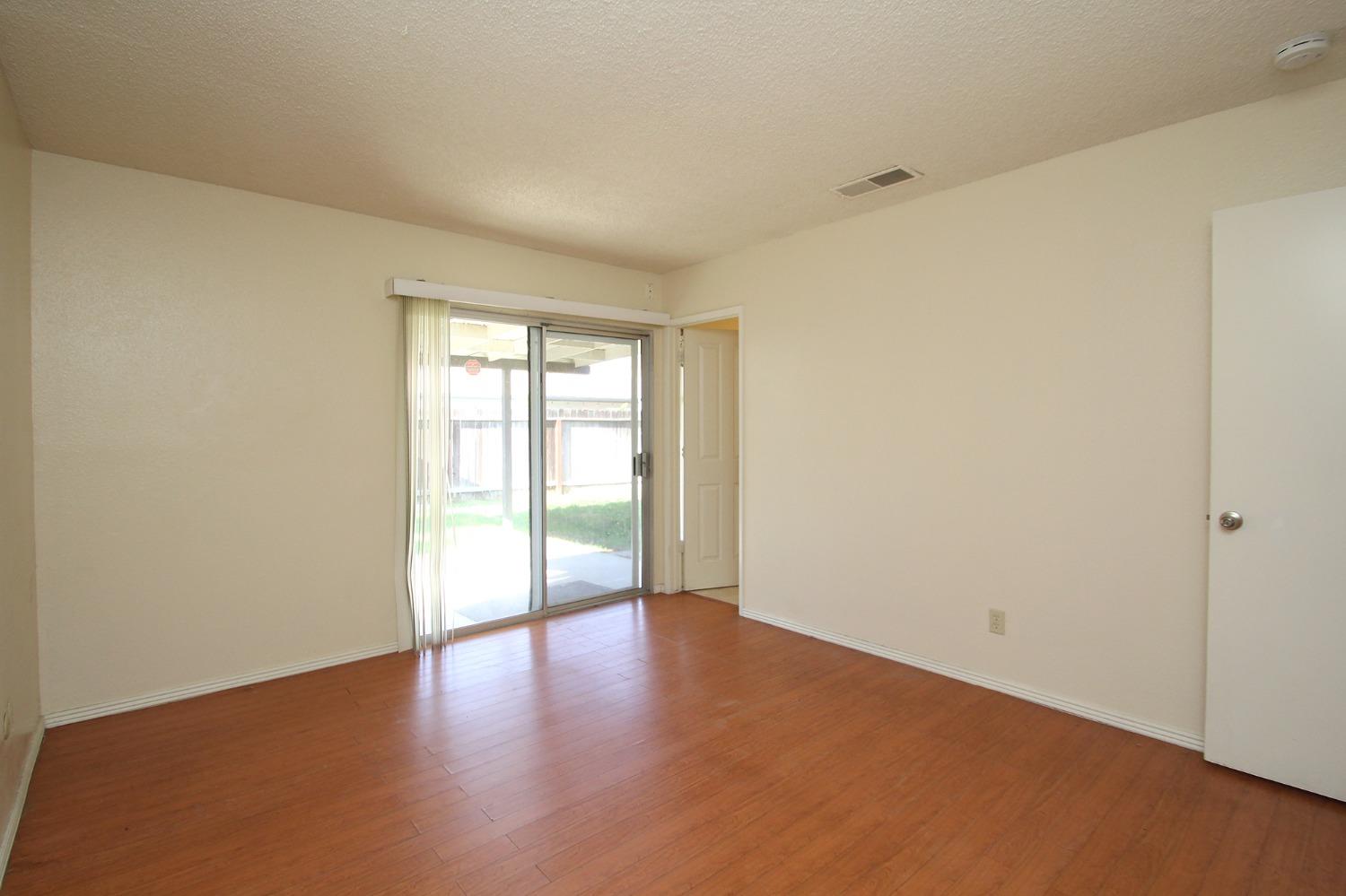 834 Fordham Avenue Clovis, CA 93611 - Photo 14 of 26 a view of an empty room with a window and wooden floor