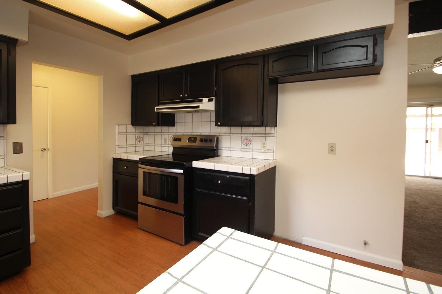 834 Fordham Avenue Clovis, CA 93611 - Photo 9 of 26 a kitchen with stainless steel appliances a stove a microwave and a refrigerator