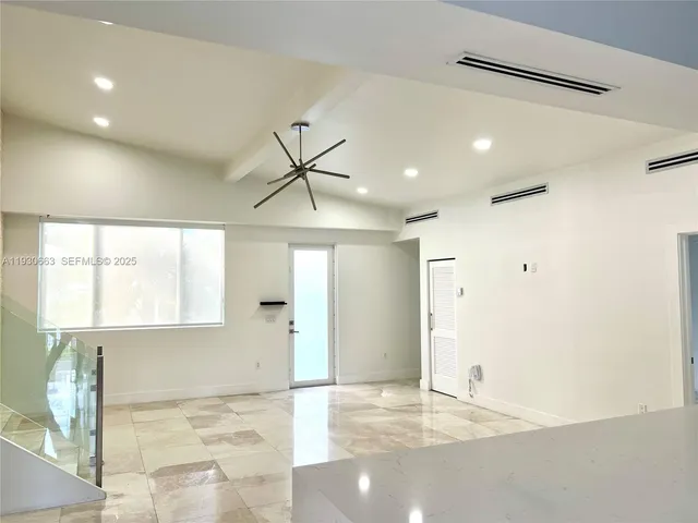 a living room with stainless steel appliances kitchen island granite countertop furniture a rug and a large window