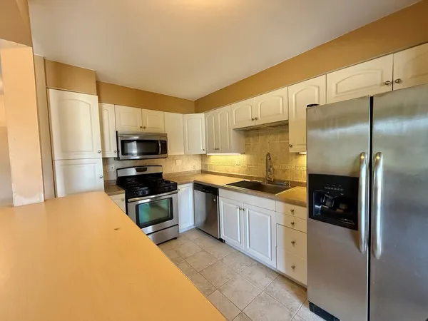 a kitchen with stainless steel appliances a refrigerator sink and stove