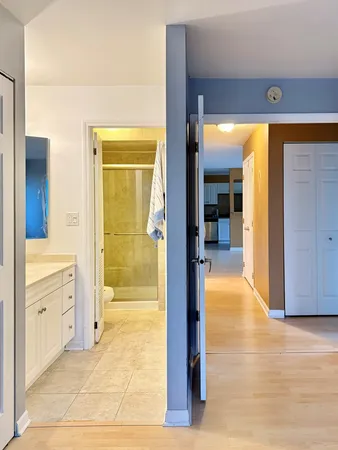 a view of a hallway with bathroom and wooden floor