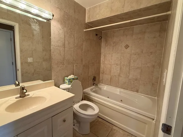 a bathroom with a granite countertop sink a toilet and shower