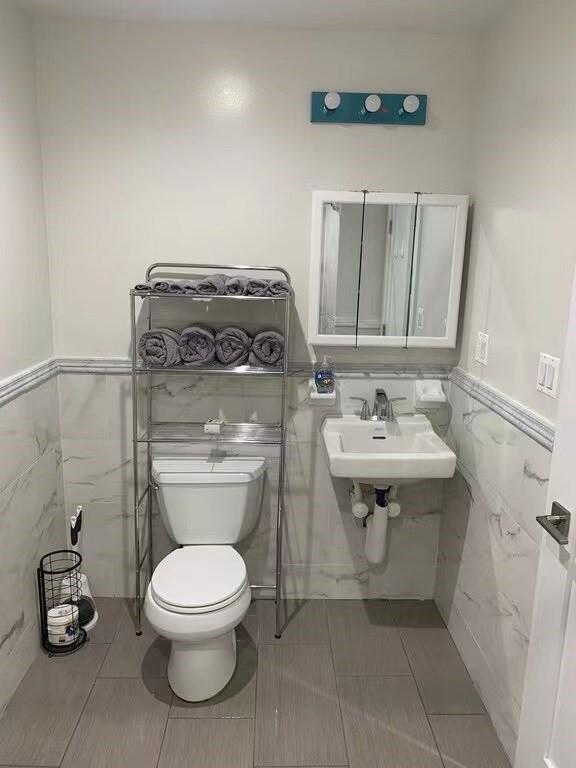 621 48th Street Brooklyn, NY 11220 - Photo 12 of 14 a bathroom with a toilet a sink and mirror