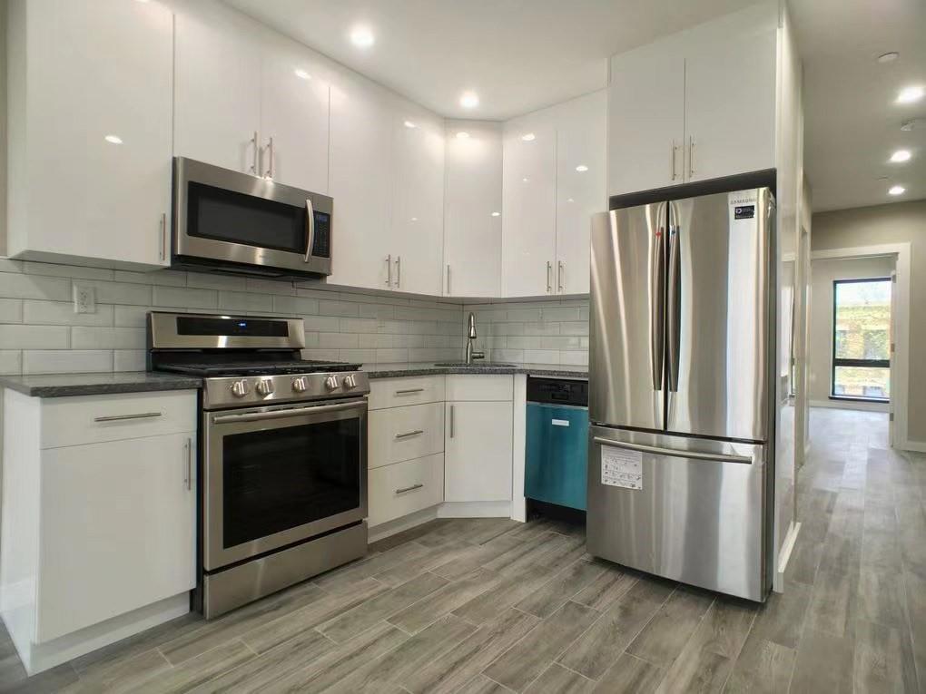 621 48th Street Brooklyn, NY 11220 - Photo 4 of 14 a kitchen with a refrigerator stove and wooden cabinets