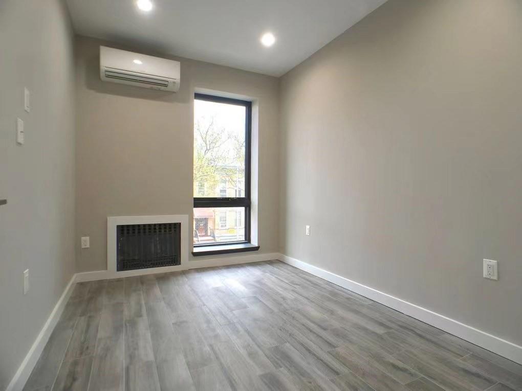 621 48th Street Brooklyn, NY 11220 - Photo 6 of 14 a view of an empty room with wooden floor and a window