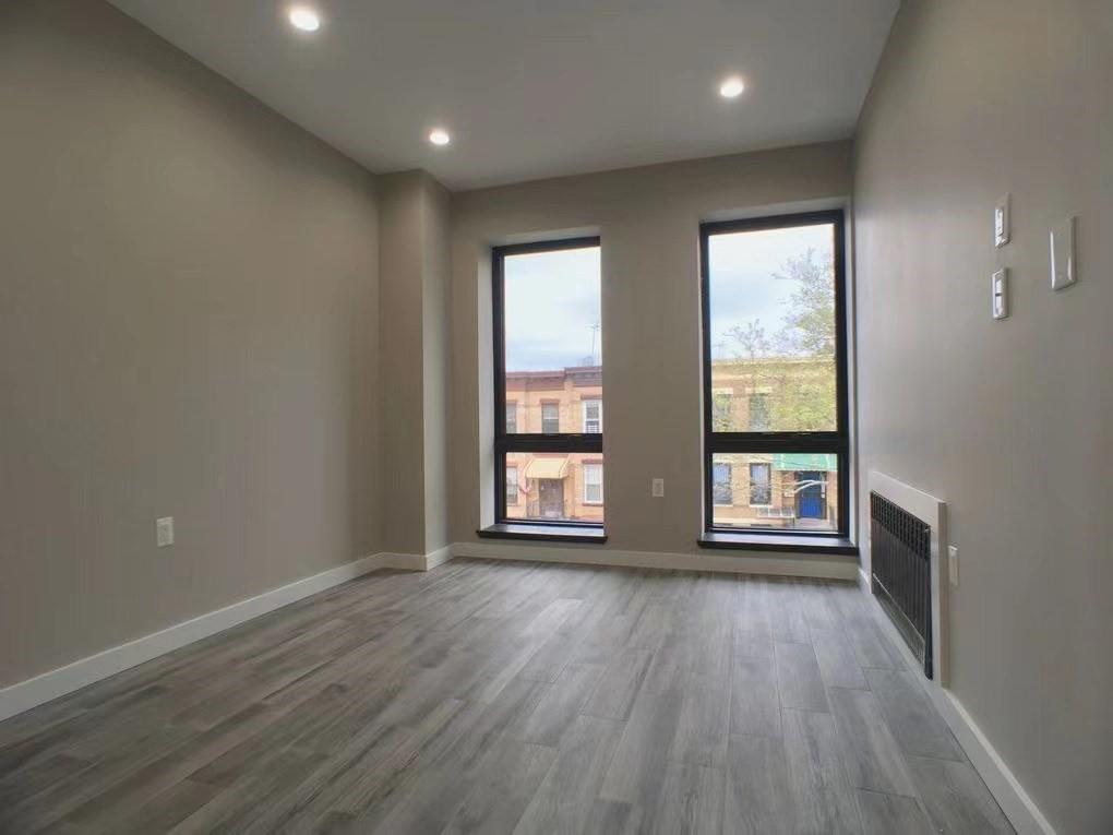 621 48th Street Brooklyn, NY 11220 - Photo 7 of 14 an empty room with wooden floor and windows
