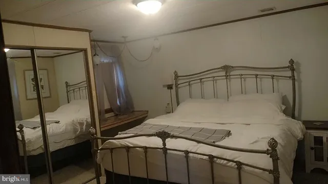 a bedroom with a bed and a mirror