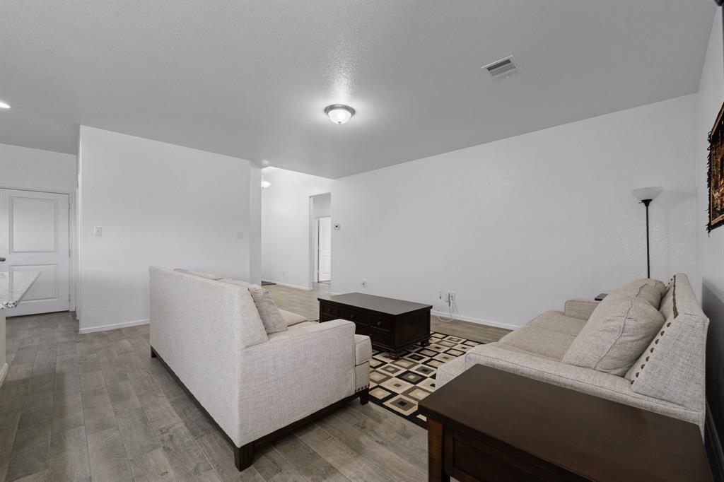 4600 Fringetree Way Crowley, TX 76036 - Photo 17 of 40 Open-concept living area featuring wood-finish flooring, recessed lighting, and a white interior door with contemporary hardware