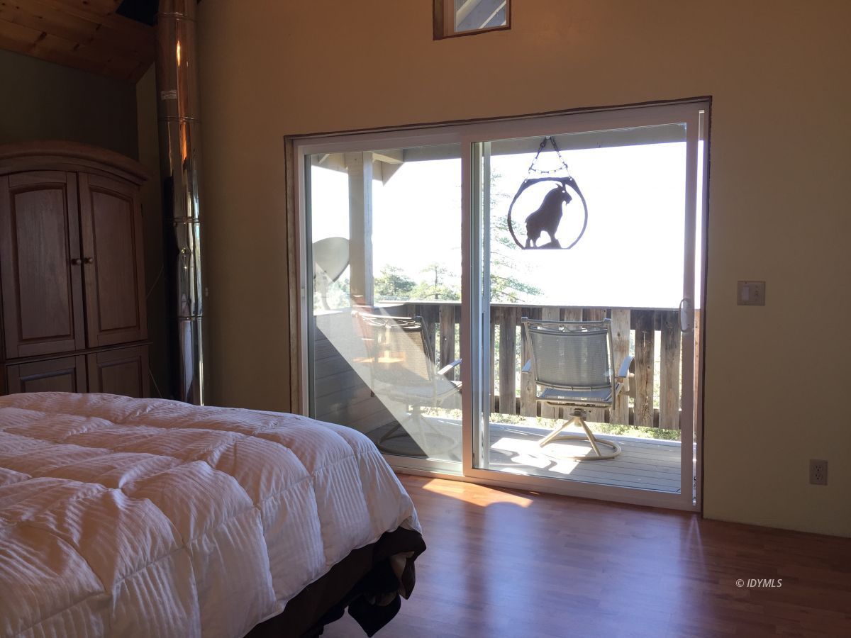 24636 Rocky Point Road Idyllwild, CA 92549 - Photo 54 of 78 a bedroom with a balcony a bed and a large window