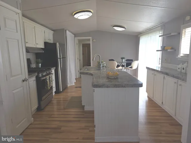 a kitchen with refrigerator cabinets and wooden floor