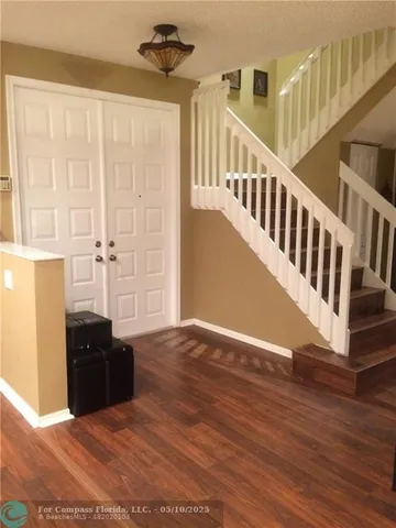 a view of a livingroom with wooden floor and furniture