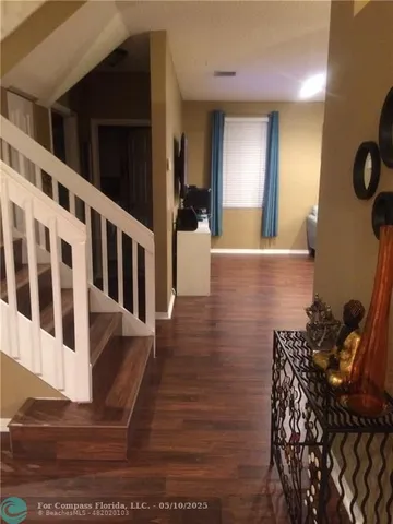 a view of entryway and hall with wooden floor