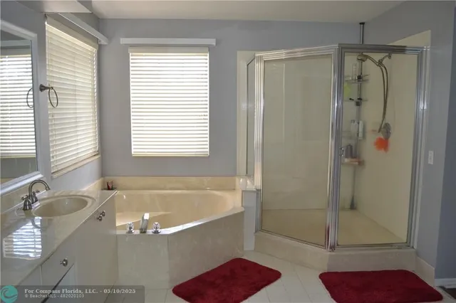 a bath tub sitting next to a bathroom sink and a shower