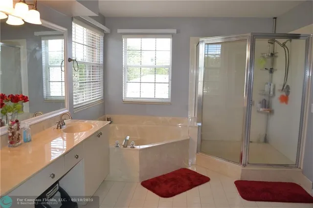 a bathroom with a tub a sink and shower