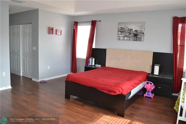 a bedroom with a bed and a potted plant on dresser