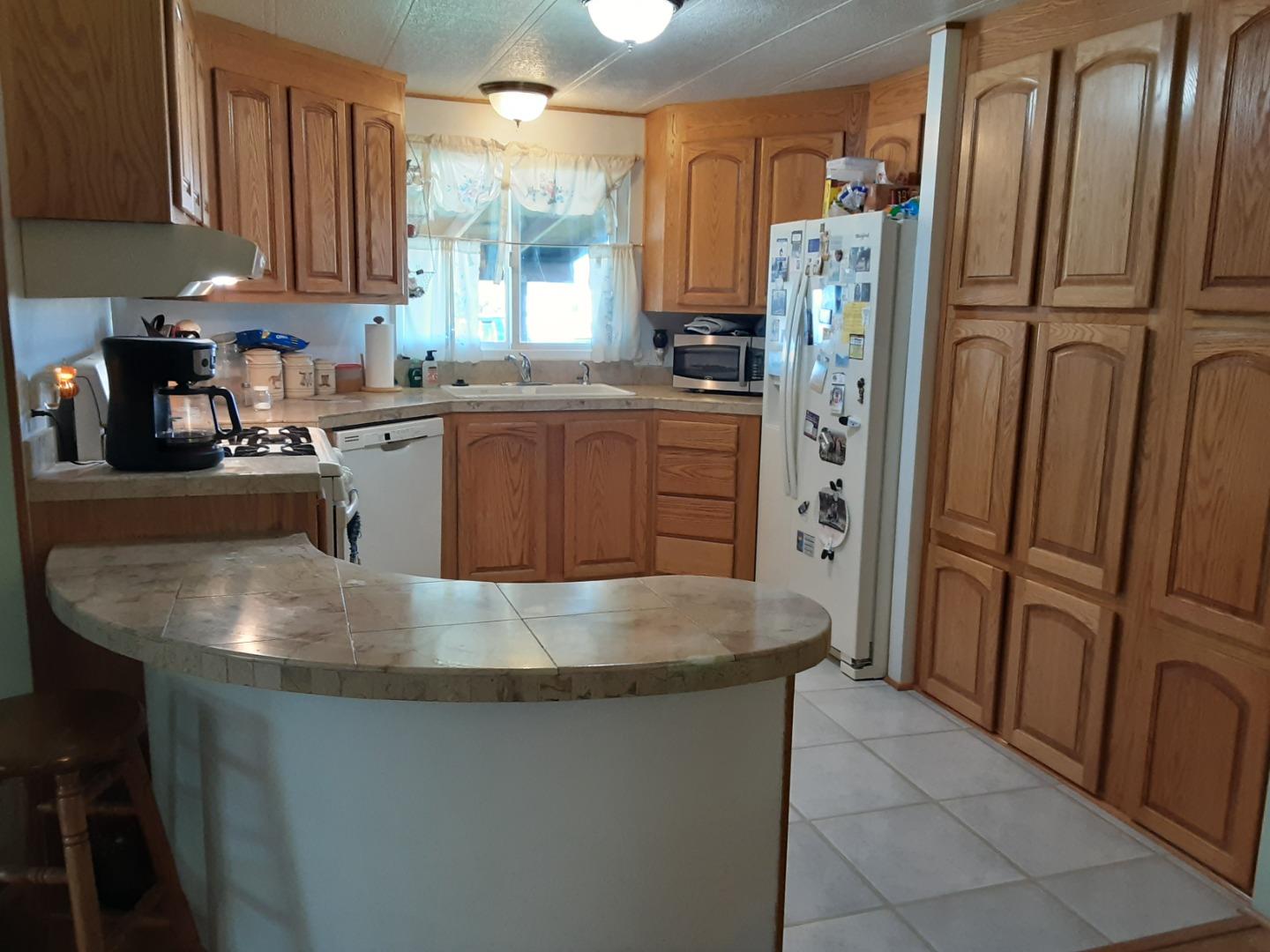 1738 H Santa Ana Road, Unit H Hollister, CA 95023 - Photo 27 of 33 a kitchen with stainless steel appliances granite countertop a refrigerator a sink a stove a washer and dryer