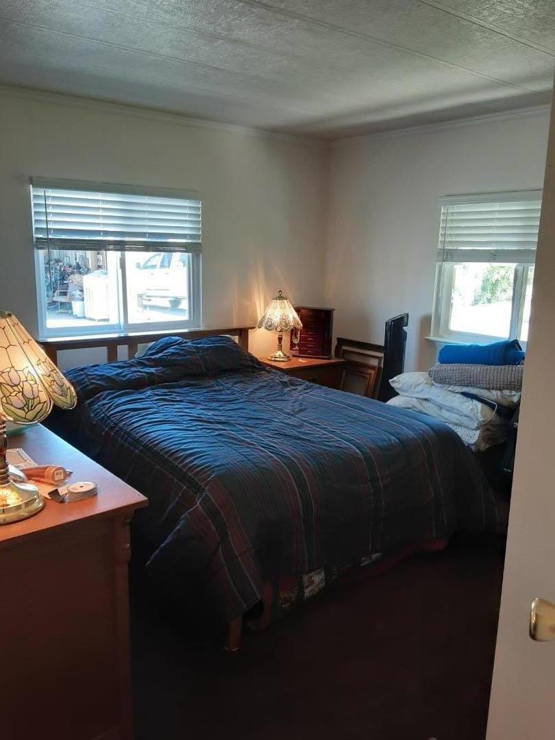 1738 H Santa Ana Road, Unit H Hollister, CA 95023 - Photo 28 of 33 a bed sitting in a bedroom next to a window