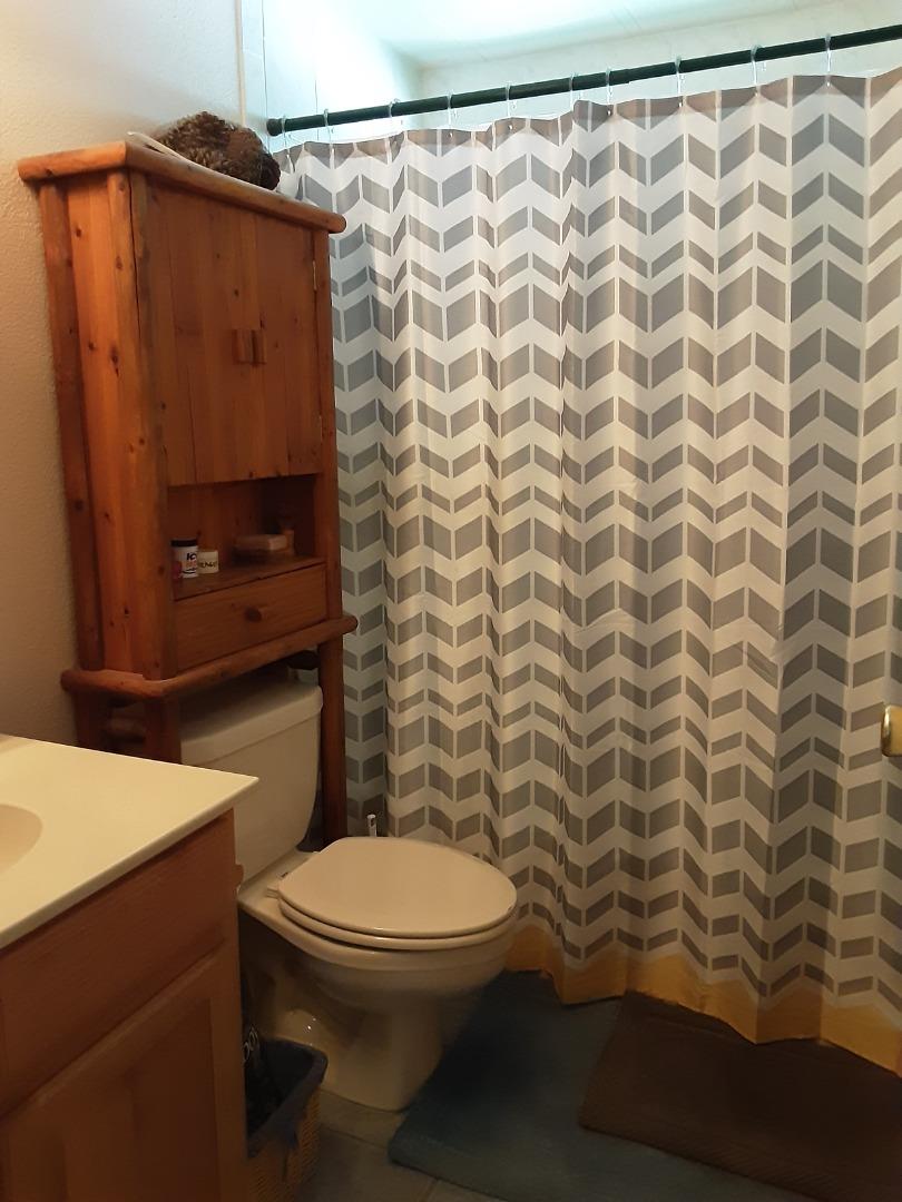 1738 H Santa Ana Road, Unit H Hollister, CA 95023 - Photo 30 of 33 a bathroom with a toilet and a shower curtain