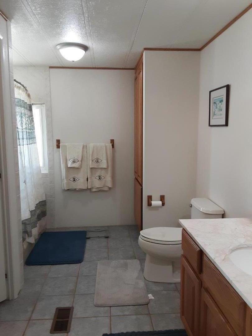 1738 H Santa Ana Road, Unit H Hollister, CA 95023 - Photo 31 of 33 a bathroom with a sink a toilet and a mirror