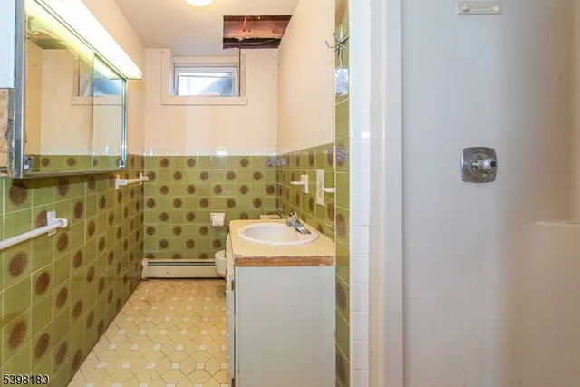a bathroom with sink shower and mirror