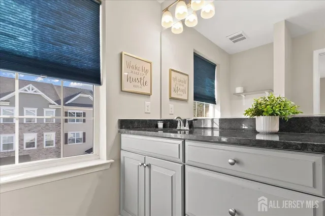 a bathroom with a granite countertop sink a large mirror and