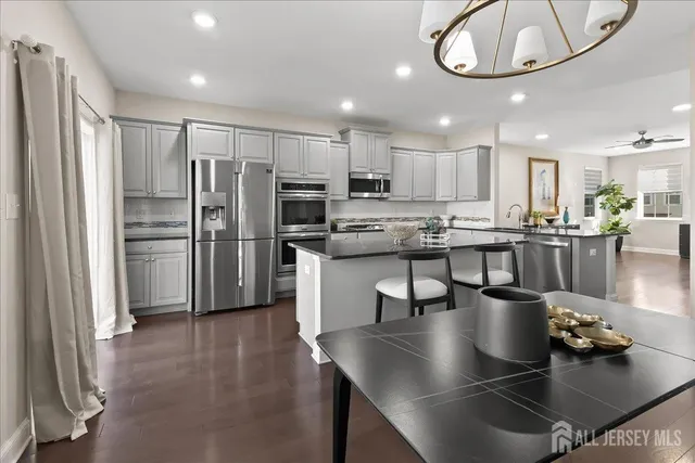 a kitchen with stainless steel appliances granite countertop a sink refrigerator and cabinets