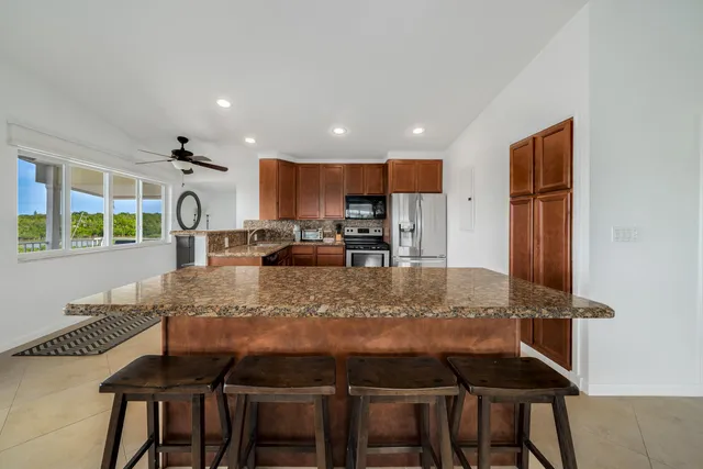 a kitchen with kitchen island granite countertop a stove and a refrigerator