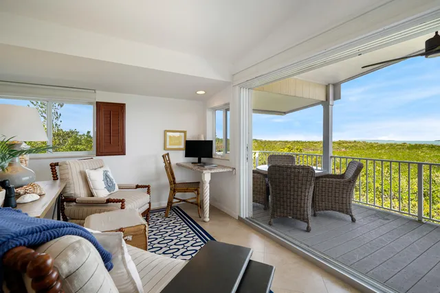 a living room with furniture floor to ceiling window next to a yard