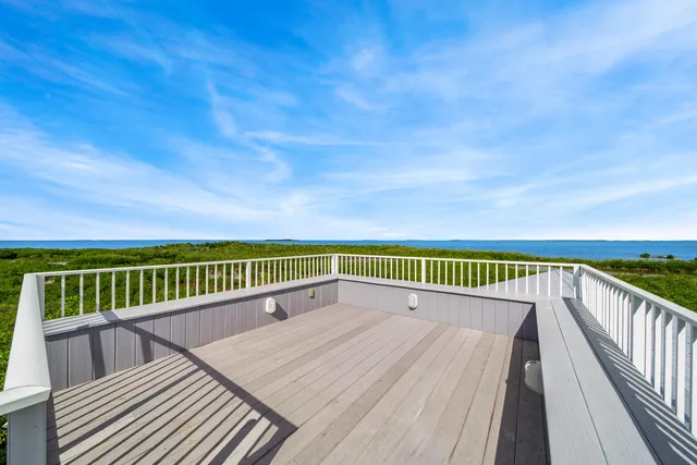 a view of a roof deck with wooden fence and floor