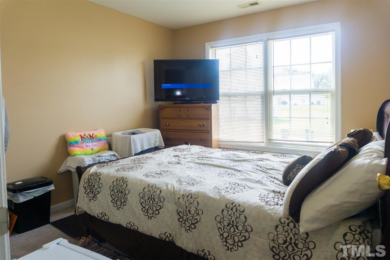 7029 Spanglers Spring Way Raleigh, NC 27610 - Photo 12 of 18 a bedroom with a bed and a flat screen tv